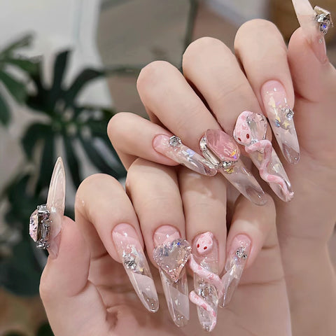 Manucure faite à la main pure portant un faux ongle autocollant glace pure à travers un patch de manucure bébé serpent rose m3331214